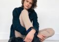 Charlie Tahan sitting with a denim jacket on