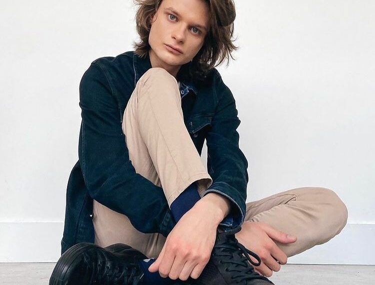 Charlie Tahan sitting with a denim jacket on