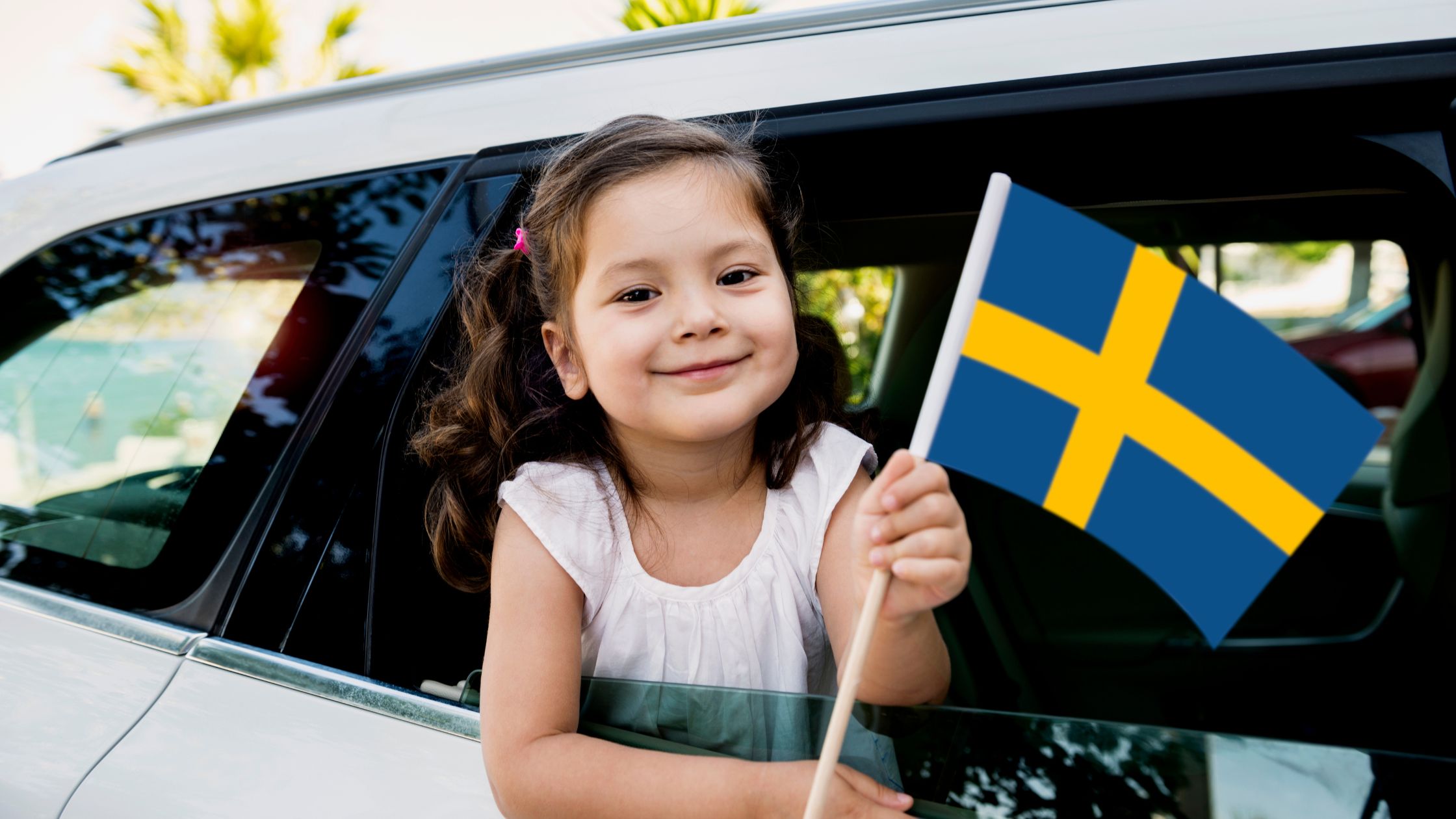 A girl holding the flag of Sweden.