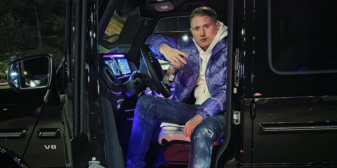 Rapper Einar posing in his car.