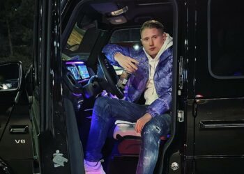 Rapper Einar posing in his car.